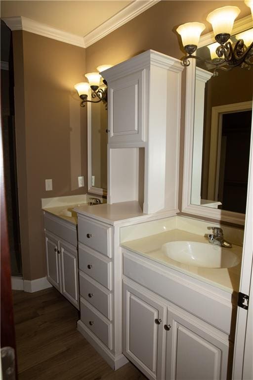 bathroom featuring wood-type flooring, vanity, an inviting chandelier, and crown molding