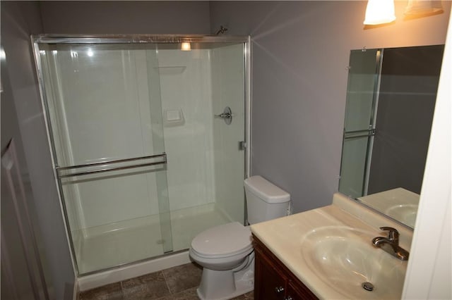 bathroom featuring vanity, an enclosed shower, and toilet