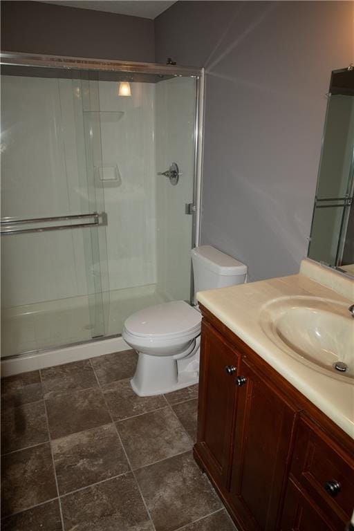 bathroom featuring vanity, toilet, and a shower with door