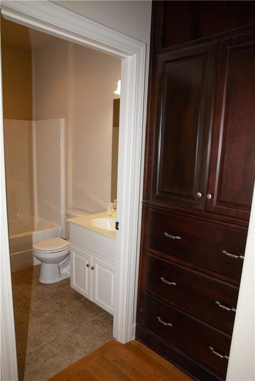 full bathroom featuring hardwood / wood-style flooring, vanity, toilet, and shower / tub combination