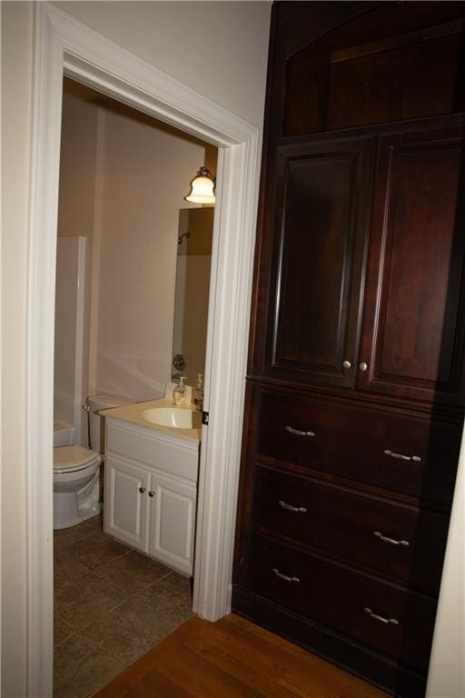 bathroom featuring vanity, hardwood / wood-style flooring, and toilet