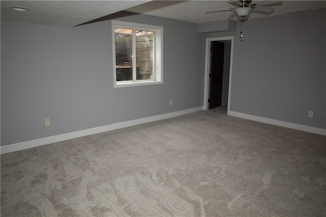 carpeted empty room featuring a textured ceiling and ceiling fan