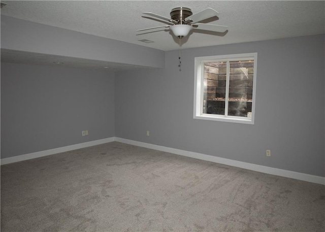 unfurnished room with a textured ceiling, carpet floors, and ceiling fan