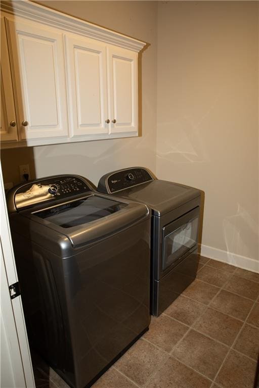 washroom with cabinets, independent washer and dryer, and tile patterned floors