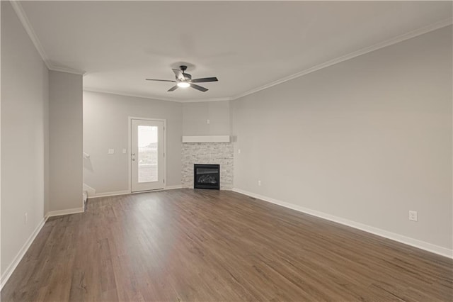 unfurnished living room featuring dark hardwood / wood-style floors, ceiling fan, crown molding, and a fireplace