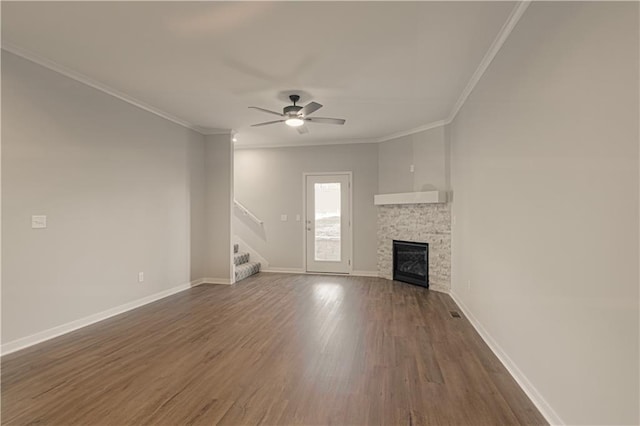 unfurnished living room featuring crown molding, a fireplace, ceiling fan, and dark hardwood / wood-style floors