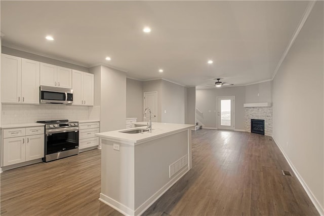 kitchen with white cabinets, an island with sink, stainless steel appliances, and sink