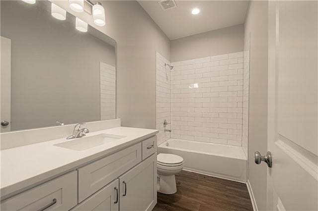 full bathroom featuring vanity, hardwood / wood-style flooring, toilet, and tiled shower / bath