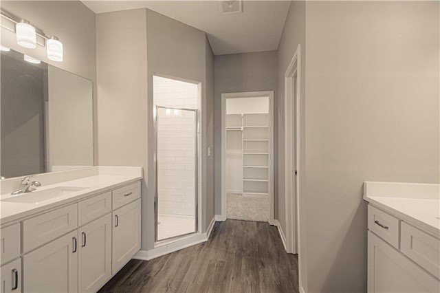 bathroom featuring hardwood / wood-style floors, vanity, and a shower with door