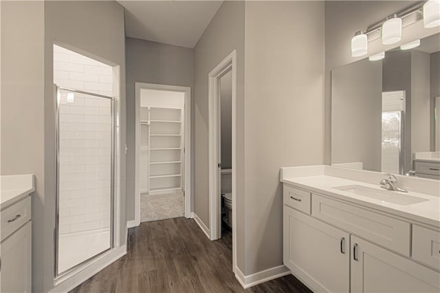 bathroom featuring hardwood / wood-style flooring, vanity, and a shower with door