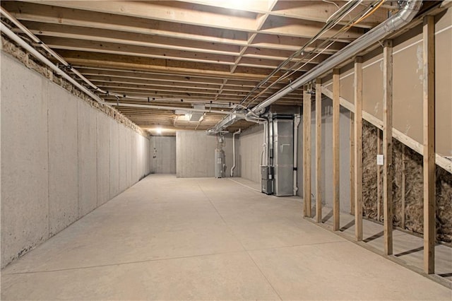 basement featuring electric water heater and heating unit