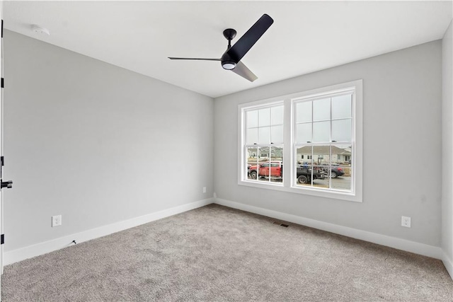 spare room featuring ceiling fan and carpet