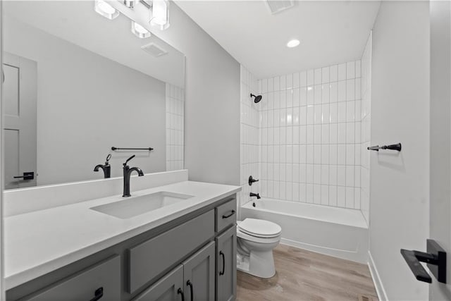 full bathroom featuring vanity, toilet, tiled shower / bath combo, and hardwood / wood-style floors