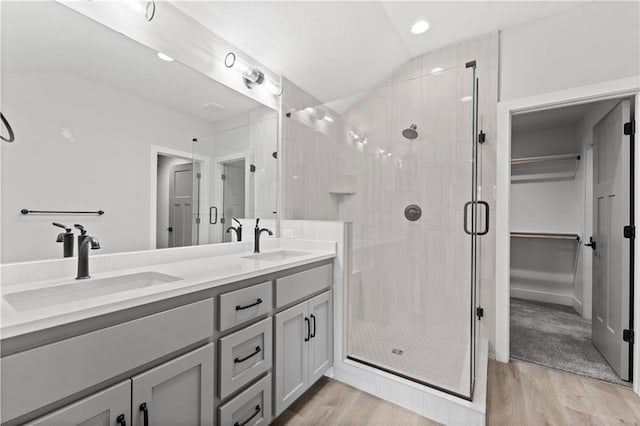 bathroom featuring lofted ceiling, wood-type flooring, and a shower with shower door