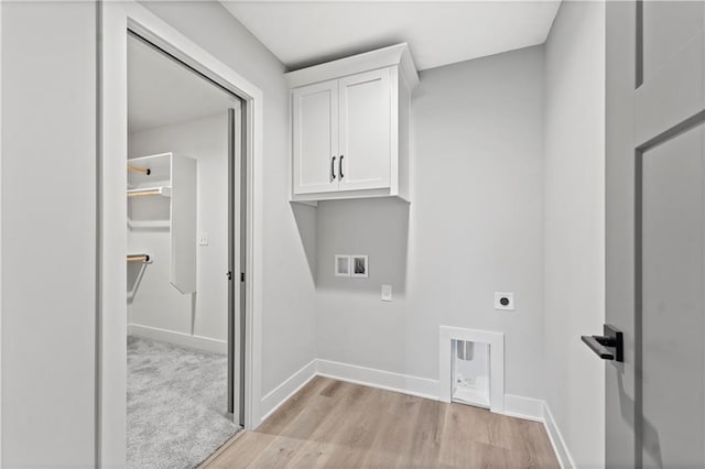 clothes washing area featuring cabinets, hookup for a washing machine, hookup for an electric dryer, and light wood-type flooring