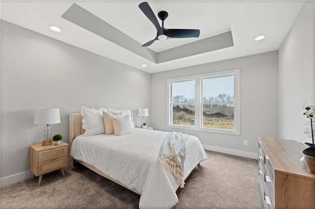 bedroom featuring ceiling fan, a raised ceiling, and carpet floors