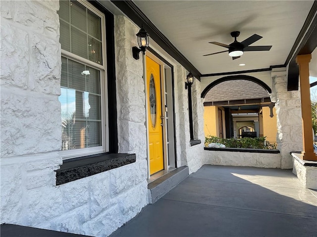 property entrance with ceiling fan and a porch