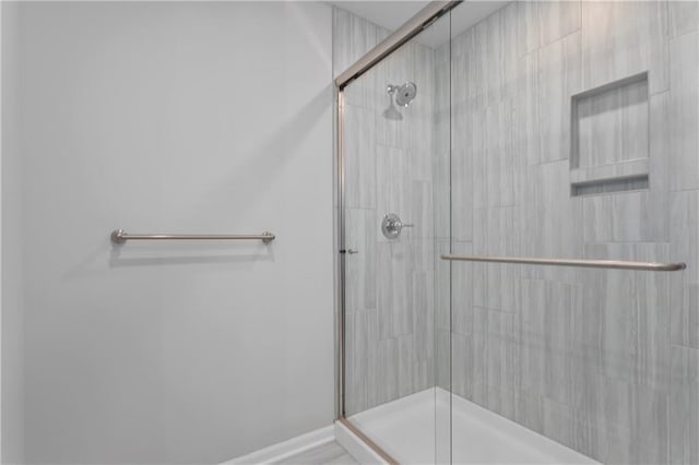 bathroom featuring a shower with shower door