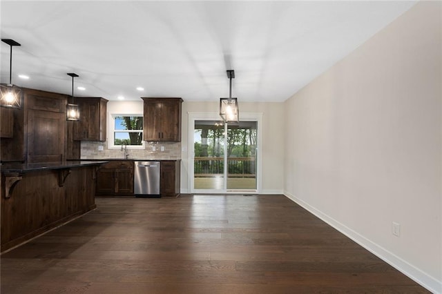 1316 N Holland Ct, Independence, MO 64056 - kitchen with stainless steel dishwasher, a kitchen bar, a sink, dark wood-style flooring, and dark brown cabinets