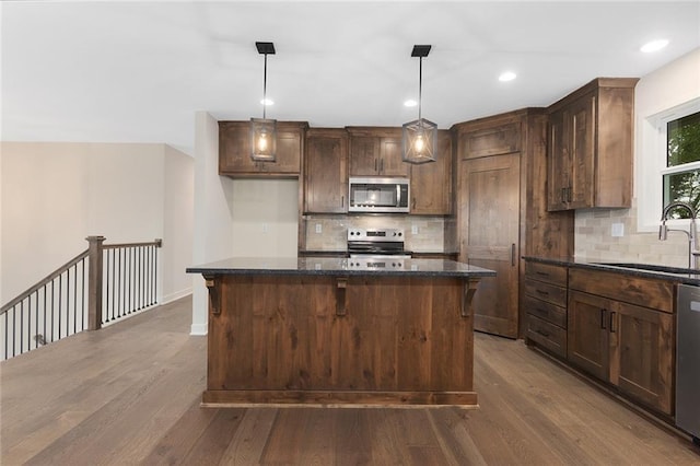 1316 N Holland Ct, Independence, MO 64056 - kitchen featuring appliances with stainless steel finishes, a sink, dark wood-type flooring, backsplash, and recessed lighting