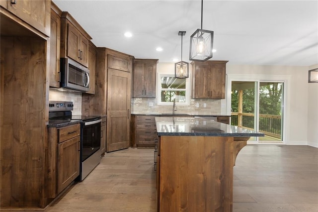 1316 N Holland Ct, Independence, MO 64056 - kitchen with stainless steel appliances, light wood-type flooring, a sink, recessed lighting, and tasteful backsplash