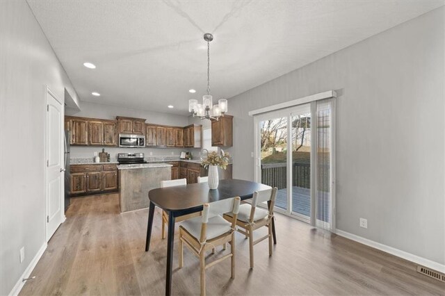 dining area with a notable chandelier and light wood-type flooring