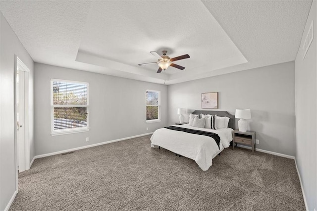 carpeted bedroom featuring a textured ceiling, multiple windows, and ceiling fan