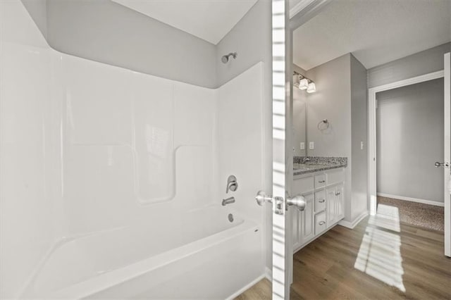 bathroom with vanity, hardwood / wood-style flooring, and bathing tub / shower combination