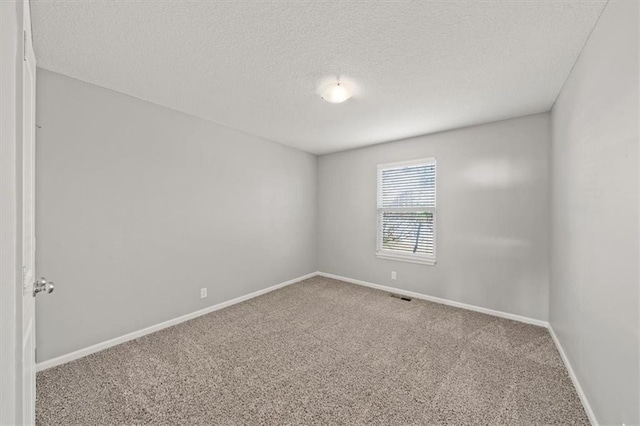 carpeted spare room featuring a textured ceiling