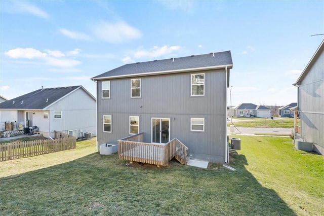 rear view of property with central air condition unit and a lawn