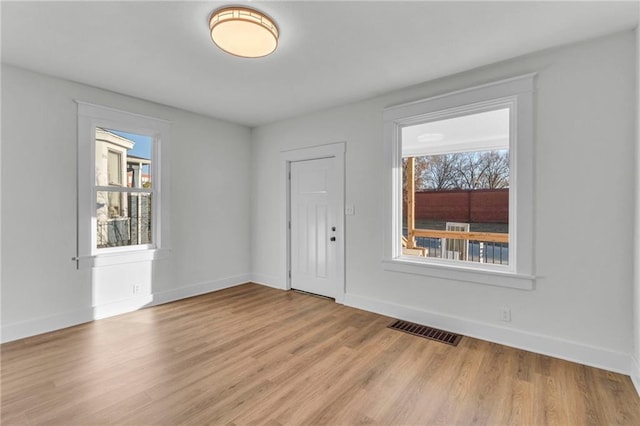 spare room featuring light hardwood / wood-style floors and a wealth of natural light