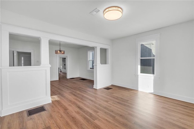 spare room with hardwood / wood-style floors and a notable chandelier