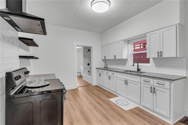 kitchen featuring light wood-type flooring, extractor fan, sink, electric range, and white cabinetry