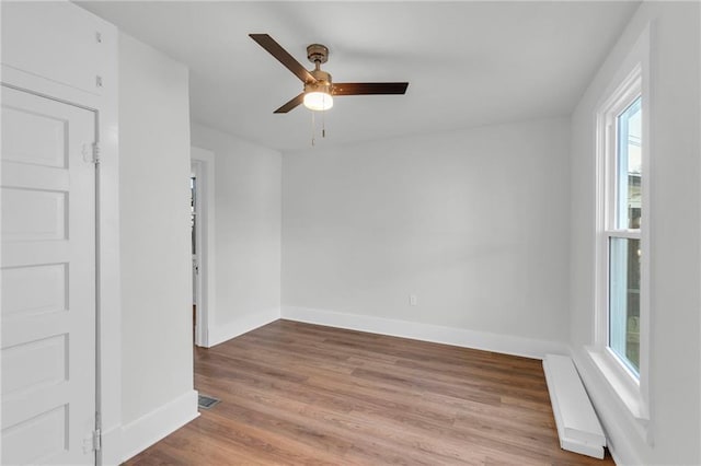 empty room with ceiling fan and light hardwood / wood-style floors