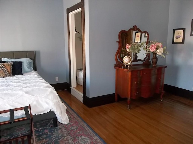 bedroom with dark hardwood / wood-style flooring