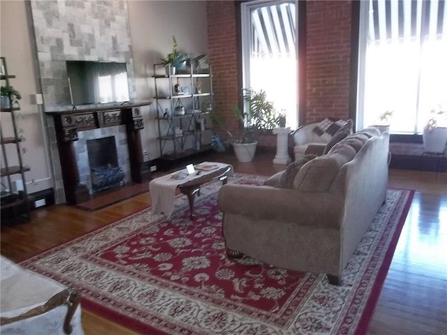 living room featuring wood-type flooring and a tile fireplace