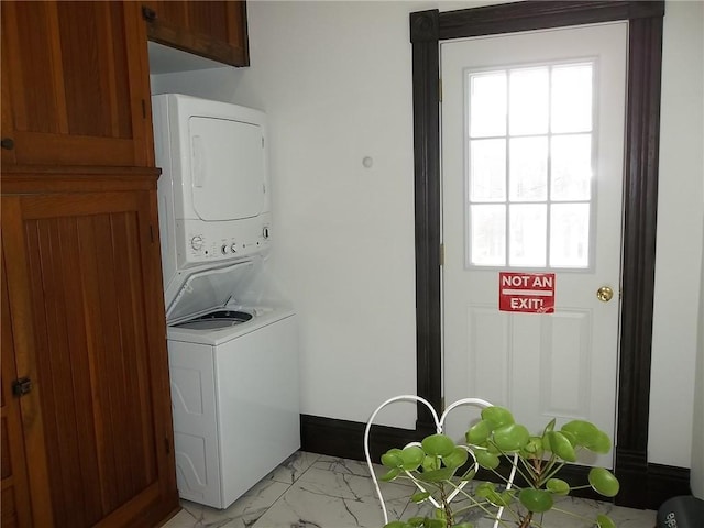 laundry area featuring stacked washer and dryer and cabinets