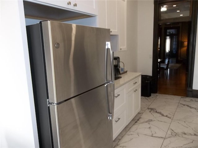 kitchen featuring white cabinetry and stainless steel refrigerator