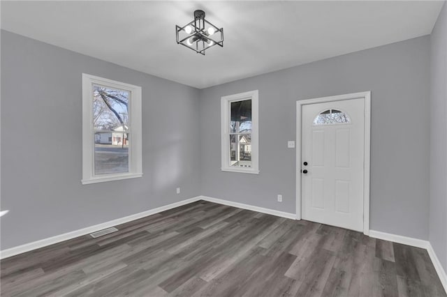 entrance foyer with dark hardwood / wood-style flooring and an inviting chandelier