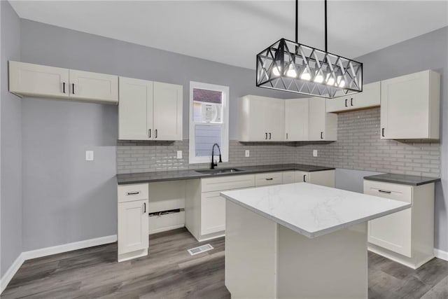 kitchen with white cabinets, a kitchen island, and sink