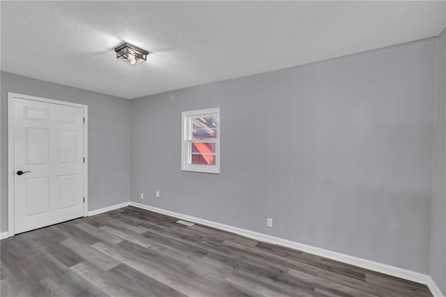 spare room with a textured ceiling and hardwood / wood-style flooring