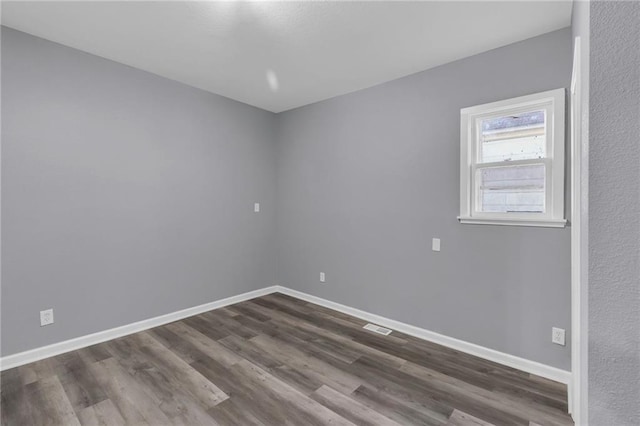 spare room with dark wood-type flooring