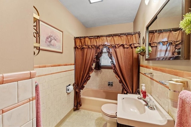 full bathroom featuring shower / bath combination with curtain, vanity, toilet, and tile walls