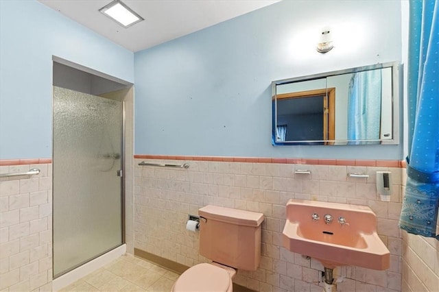 bathroom with sink, tile walls, an enclosed shower, and toilet