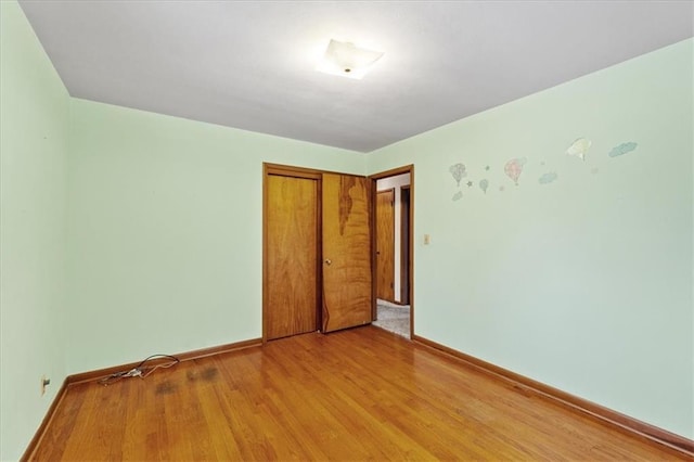 unfurnished bedroom with a closet and light wood-type flooring