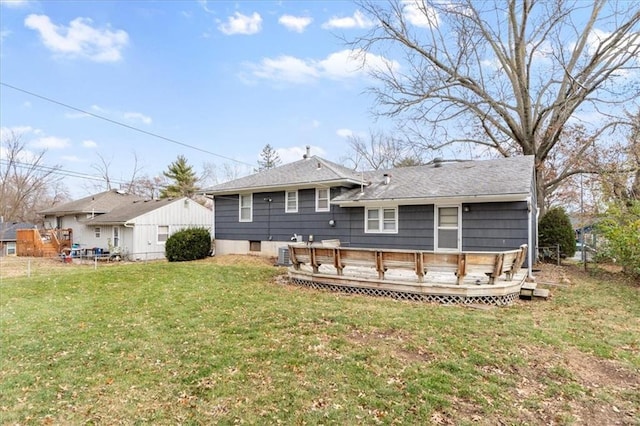 rear view of house with central AC unit, a yard, and a deck