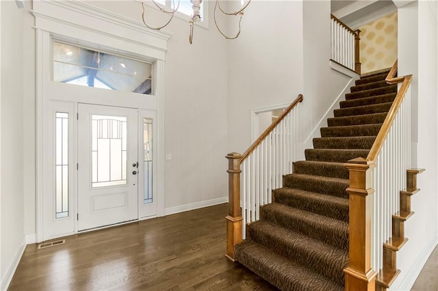 9509 W 164th St, Stilwell, KS 66085 - foyer entrance featuring dark wood-type flooring, stairs, healthy amount of natural light, a chandelier, and a towering ceiling