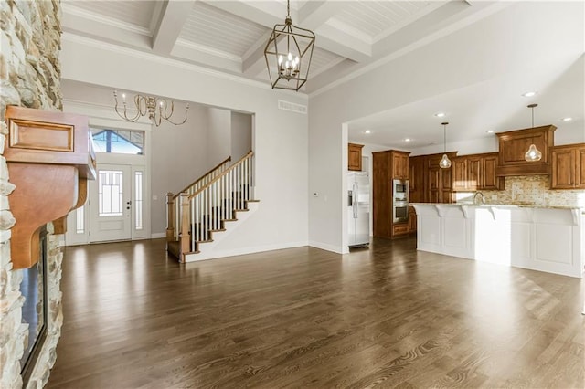 9509 W 164th St, Stilwell, KS 66085 - unfurnished living room with a chandelier, beamed ceiling, dark wood-style floors, recessed lighting, and stairway