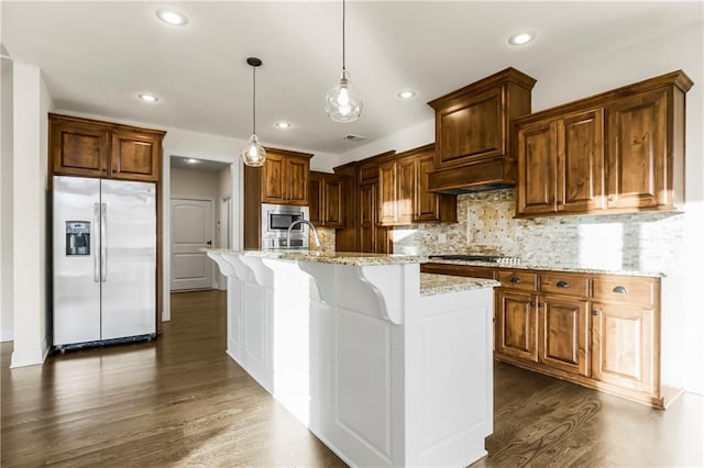 9509 W 164th St, Stilwell, KS 66085 - kitchen with appliances with stainless steel finishes, light stone counters, recessed lighting, dark wood finished floors, and an island with sink