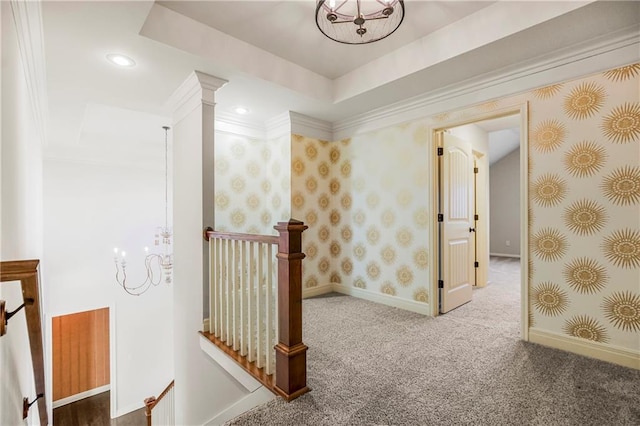 corridor featuring a tray ceiling, crown molding, and carpet flooring